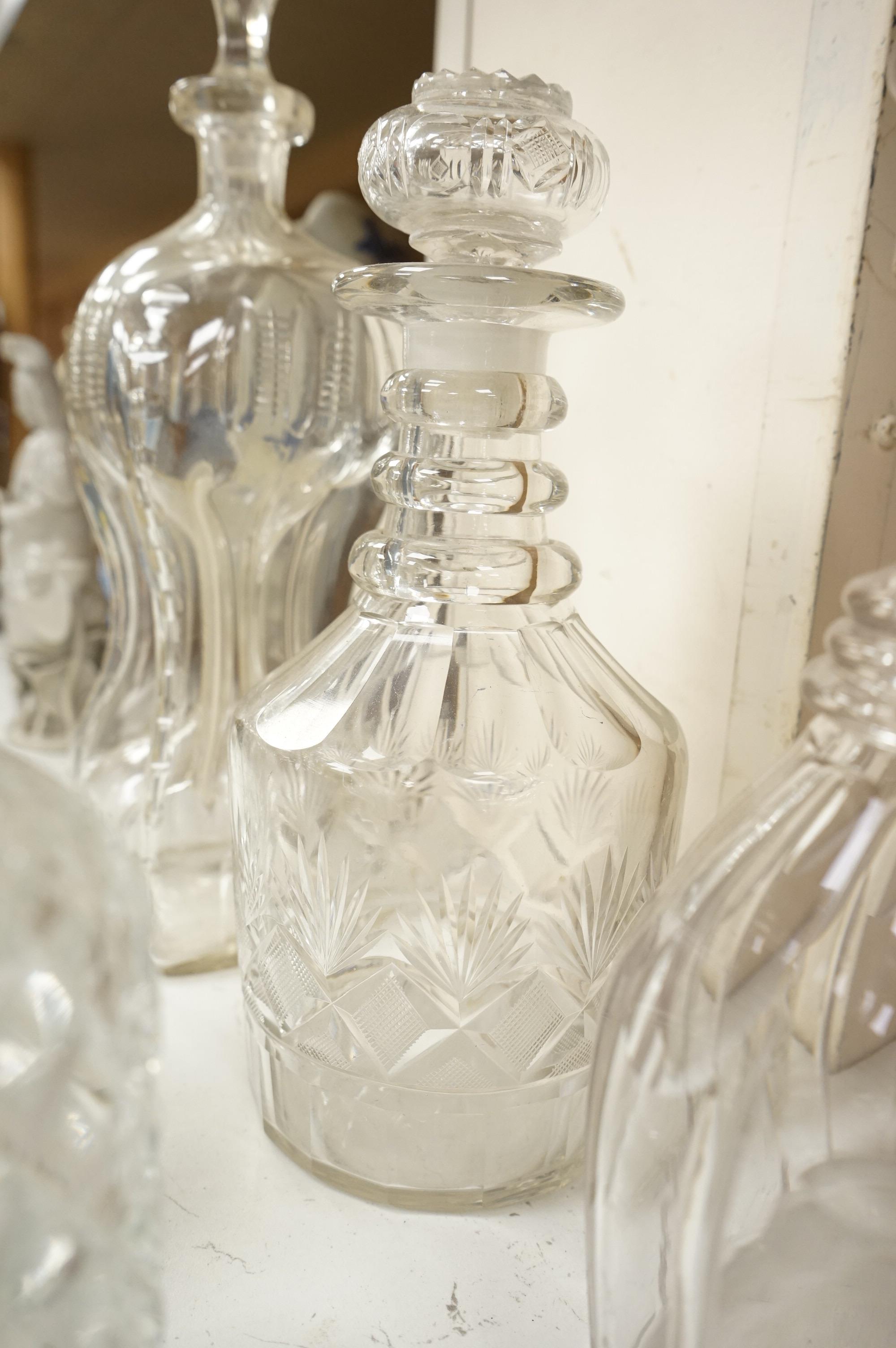 Six 19th century and later cut glass decanters and stoppers, one with white metal acorn design collar, largest 37cm high